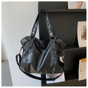 Detail of black large capacity tote bag with soft PU leather texture and silver rivets
