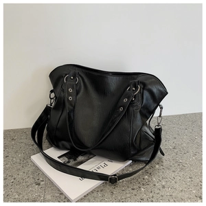 Detail of classic black large tote bag with adjustable metal buckle and PU leather texture