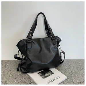 Detail of black pebbled leather tote bag showing large capacity and metal hardware