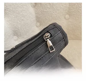 Macro detail of high-quality smooth metal zipper and gray suede bag top texture