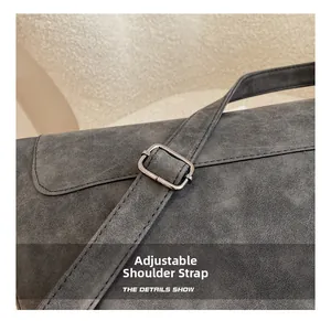 Detail of adjustable shoulder strap with silver metal buckle on a grey hobo bag