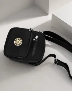 Detail of black waterproof nylon crossbody bag featuring double front zipper pockets