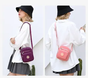 Detail of lightweight oxford fabric crossbody bags in purple and pink for daily use