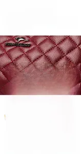 Detail shot of the wine red quilted leather handbag zipper and smooth metal hardware