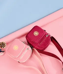 Detail view of nylon crossbody bags showing dual zip main compartments and adjustable straps