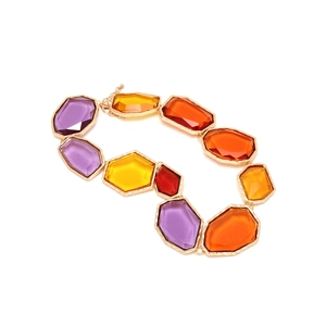 Détail de pendentifs géométriques en résine colorée dans des cadres dorés martelés