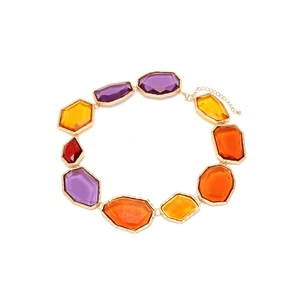 Détail du collier en résine géométrique irrégulière avec cristaux colorés et bord doré
