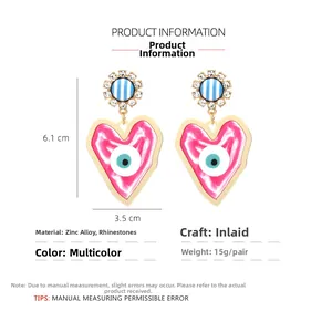 Detailed view of oversized heart earrings with evil eye motif and size dimensions