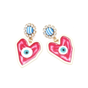 Detailed view of heart-shaped devil eye earrings with red enamel and pavé rhinestones