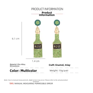 Detail of champagne bottle earrings with green rhinestones and ROSE inscription