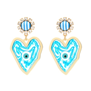 Bohemian style gold heart earrings with evil eye element and crystals on white background