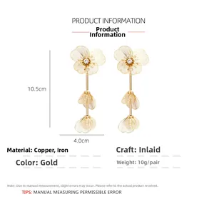 Detailed view of layered gold flower earrings with crystals and size markings