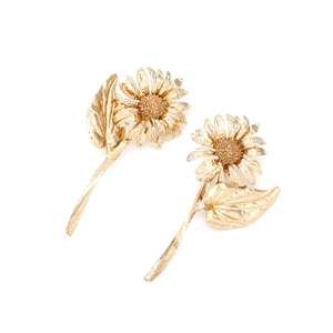 Detailed close-up of golden sunflower earrings featuring realistic metal petal textures