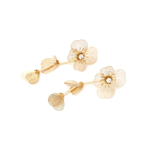 Close-up of golden multi-layer metal flower earrings with sparkling zircon centers