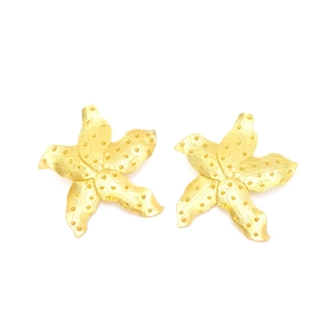 Golden flower earrings with hammered texture and dot detailing on a white background