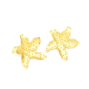 Golden starfish stud earrings with a brushed matte texture and raised dot design