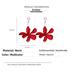 Detail shot of handmade red resin flower earrings showing dimensions of 9.8cm by 6.3cm