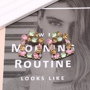 Detailed close-up of colorful square crystal earrings with gold alloy frame setting