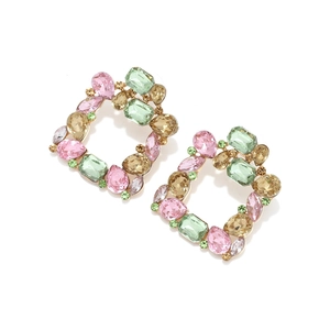 Detailed macro shot of square geometric earrings with colorful inlaid crystals and gold finish