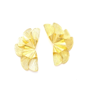 Detailed view of golden fan-shaped leaf earrings with textured brushed metal finish