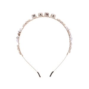Détail d'un serre-tête artisanal en fil doré avec perles MAMA et pierres de bois naturel