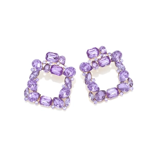 Macro shot of purple crystal square earrings with geometric multifaceted gemstones and gold base