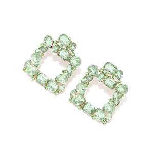 Close-up of square hollow earrings featuring light green crystals set in golden alloy