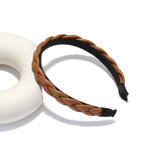 Serre-tête en cuir tressé marron avec design torsadé élégant sur fond blanc épuré