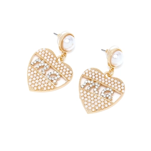 Détail de boucles d'oreilles en forme de coeur avec perles blanches et design de lettres