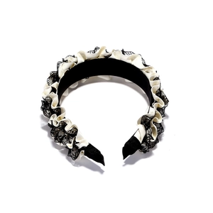 Detail of ruffled lace headband with black and cream pleated fabric and rhinestone accents