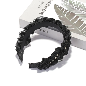 Pleated black fabric headband with lace trim and rhinestones shown at a 45-degree angle