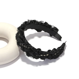 Detail of black lace pleated headband with delicate rhinestones and satin trim