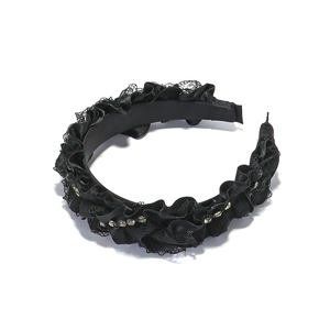 Detail of pleated satin headband with lace edge and sparkling rhinestone embellishments