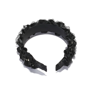 Close-up of pleated black lace headband with delicate rhinestones and satin finish