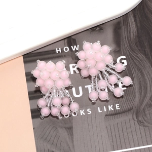 Detail of pink matte beaded floral tassel earrings with intricate woven beadwork