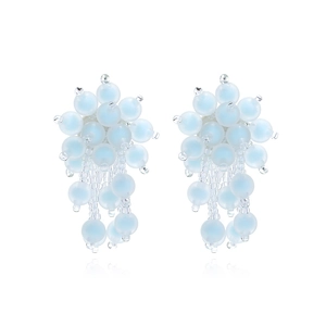 Macro shot of light blue matte beads and clear seed bead tassels on handmade earrings