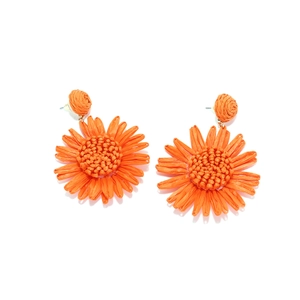Gros plan sur des boucles d'oreilles tournesol en raphia orange tissées à la main