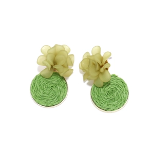 Detail of handmade resin flower earrings with woven green raffia texture and golden metal base