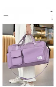 Detail of purple travel duffle bag featuring multi-pocket design and adjustable strap