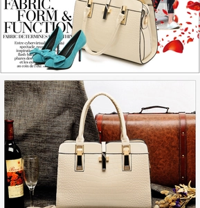 Détail d'un sac beige motif crocodile avec bijoux dorés et escarpins bleus en daim