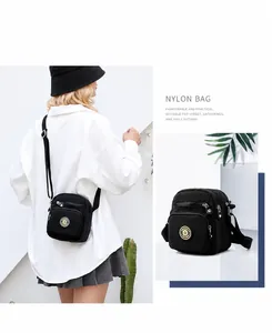 Detail of black nylon crossbody bag with multi-layer zippers and adjustable strap