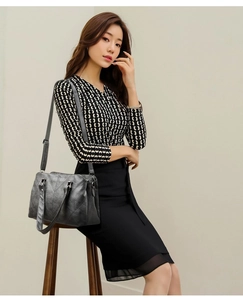 Side view of dark grey faux leather tote bag with V-shaped stitching and long strap