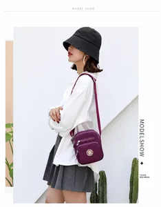 Outdoor model shot of a purple waterproof oxford crossbody bag with dual zip layers