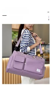 Detail of light purple waterproof nylon travel bag shown on shoulder with adjustable strap