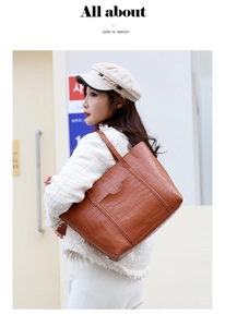 Dettaglio della borsa tote color caramello con stampa coccodrillo indossata da una modella