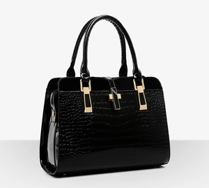 Détail d'un sac à main noir motif crocodile avec boucle en H dorée et finitions brillantes