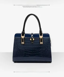 Détail du sac à main bleu foncé à texture crocodile avec boucles métalliques dorées