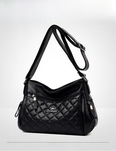 Detail of black crossbody bag with diamond quilted texture and silver zipper pockets