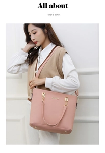 Close-up of pink leather handbag with gold logo and shoulder strap detail