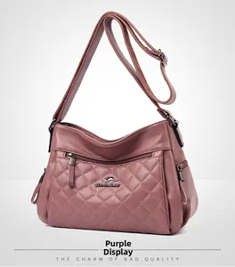 Detail of purple quilted crossbody bag with multiple zippers and textured faux leather finish